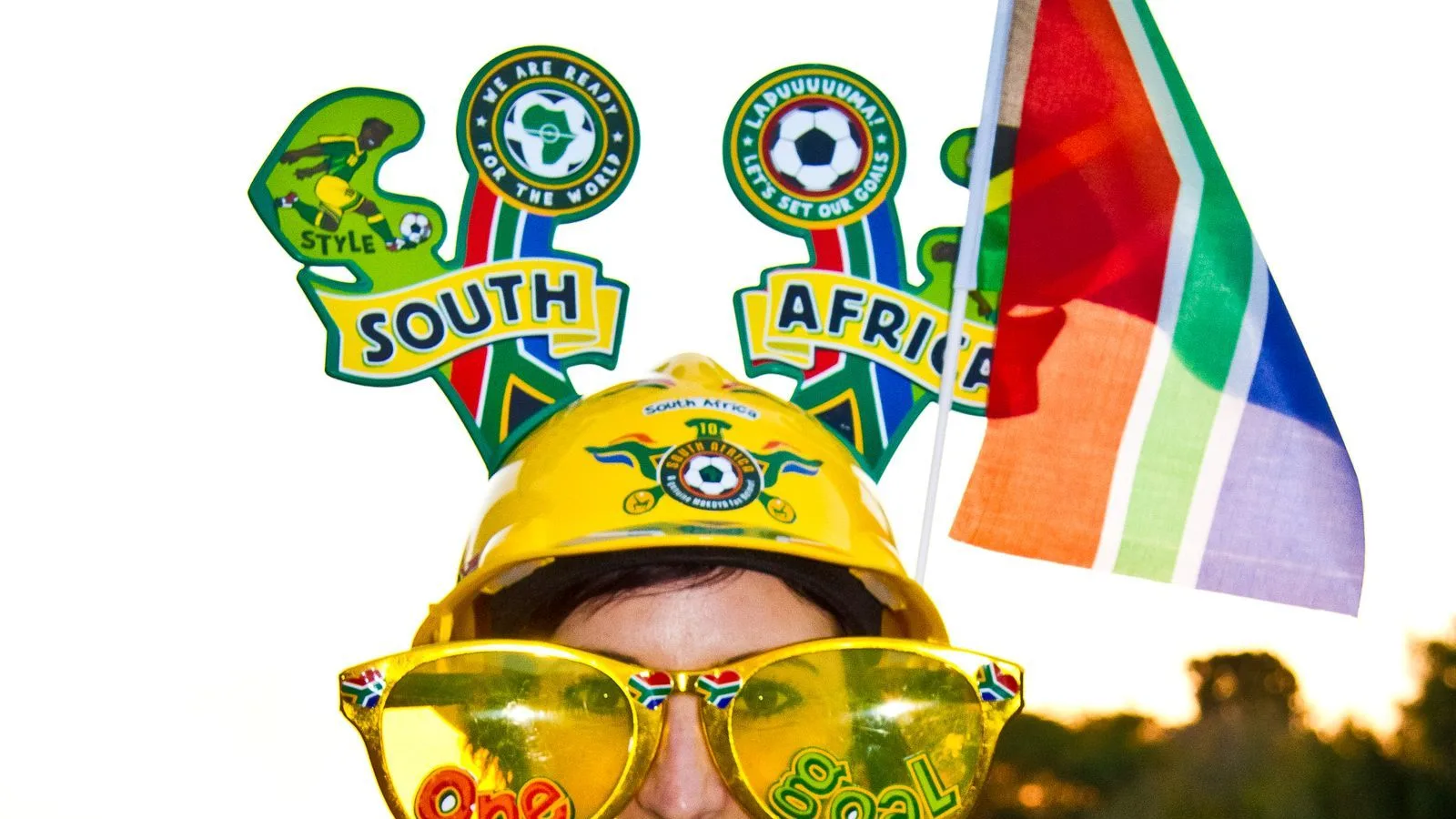 A South Africa supporter in a yellow Bafana Bafana shirt with a national flag and novelty glasses — South Africa beat South Korea 1-0 in Monterrey to reach the World Cup 2026 knockouts for the first time