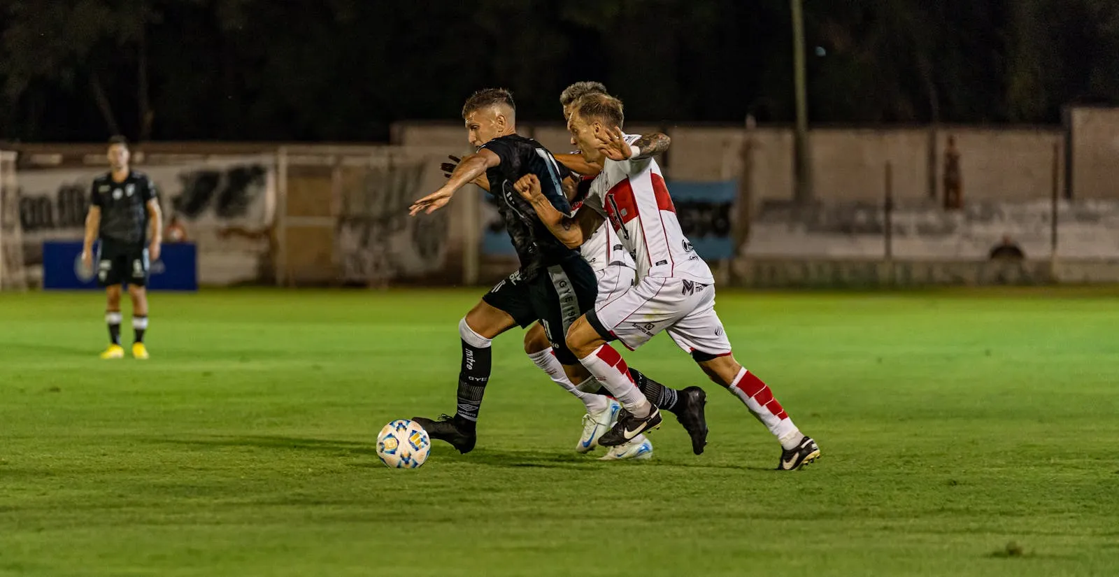 Players chase the ball under floodlights — the fatigue window between the UCL final and the 2026 World Cup opener