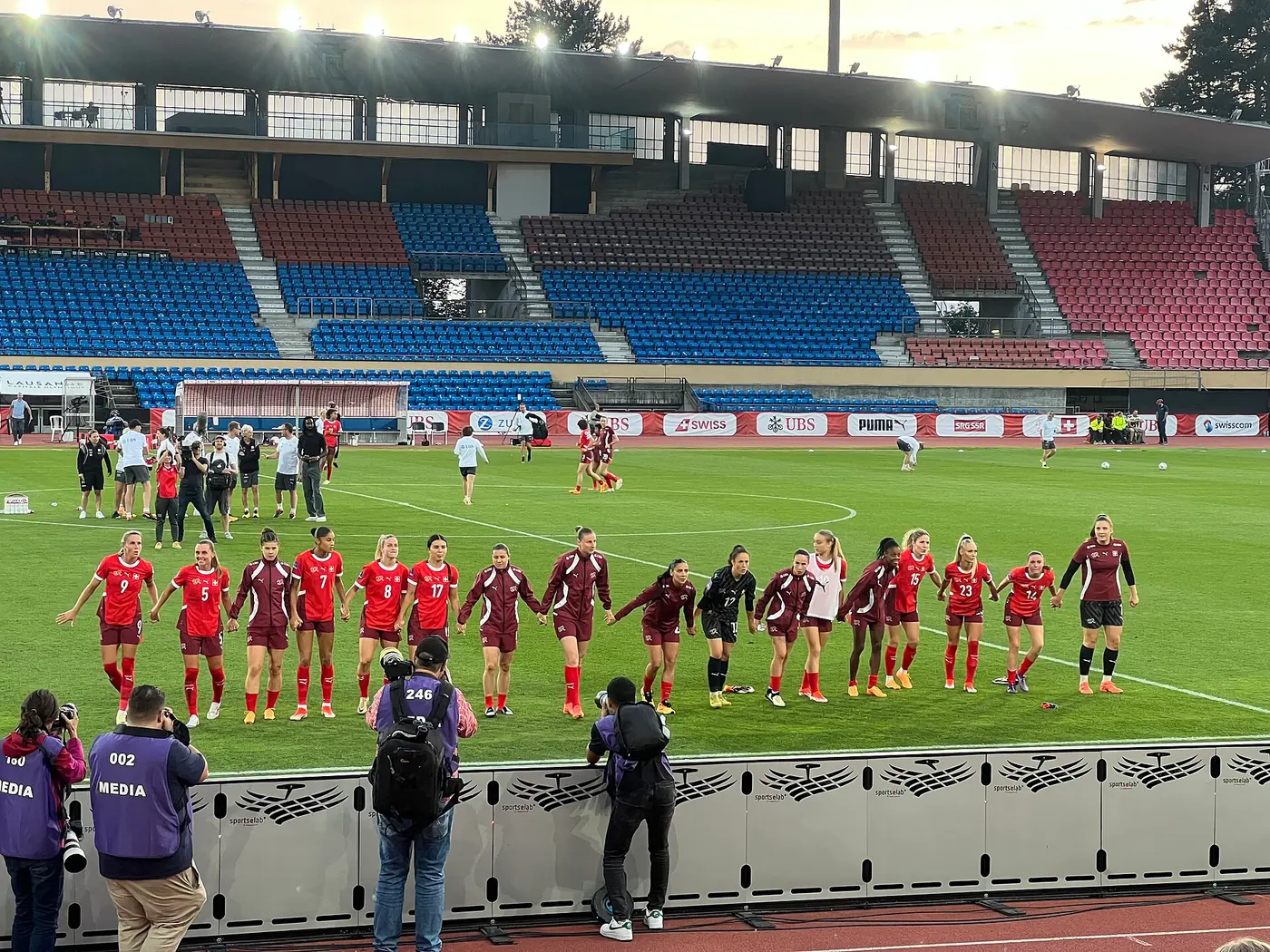 Switzerland supporters in red wave flags in the stands, evoking Switzerland's penalty shootout win over Colombia in the World Cup 2026 Round of 16 in Vancouver on July 7