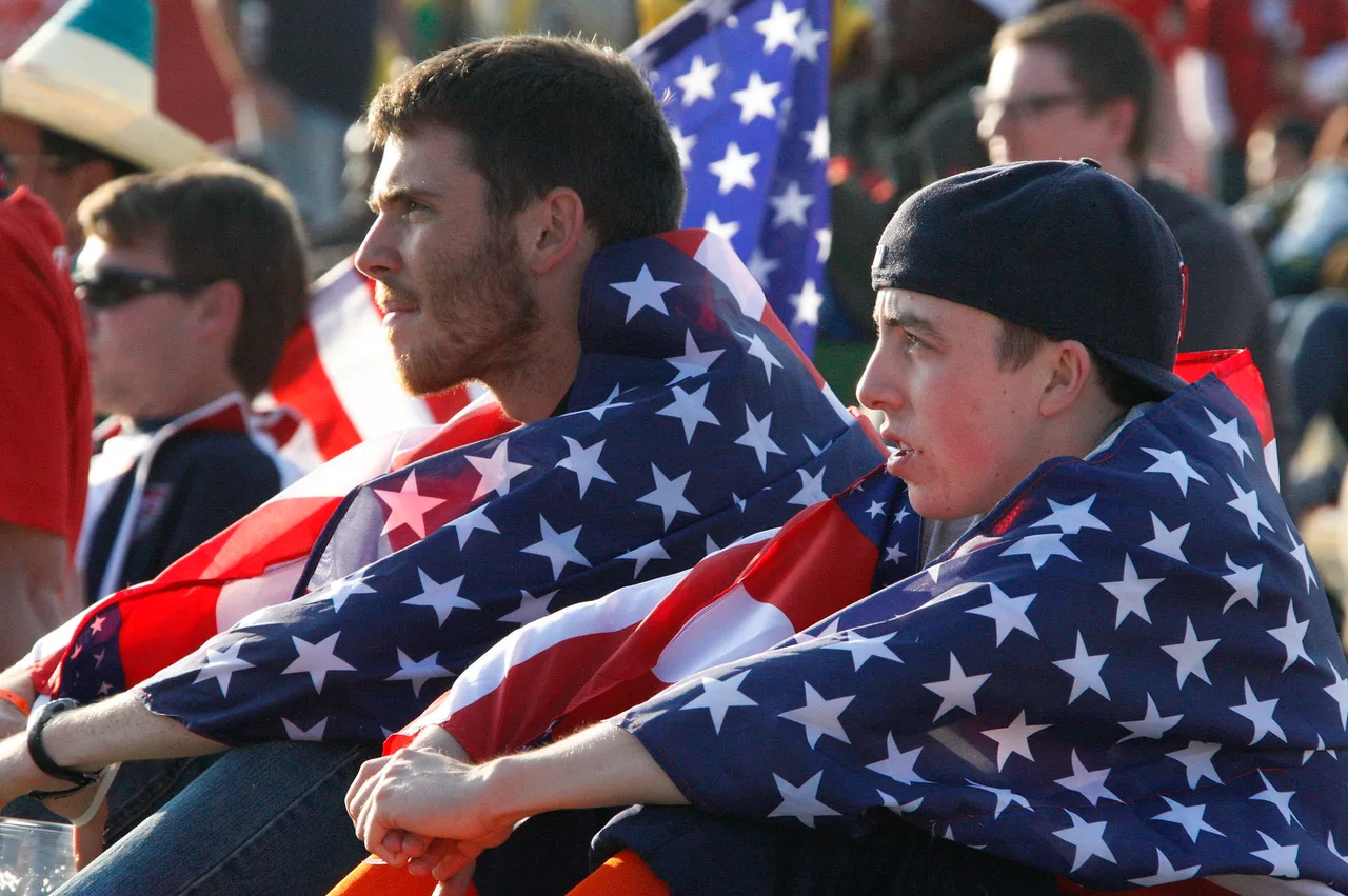 United States supporters wave Stars and Stripes flags in the stands, evoking the USMNT's 4-1 Round of 16 defeat to Belgium at World Cup 2026 in Seattle on July 6